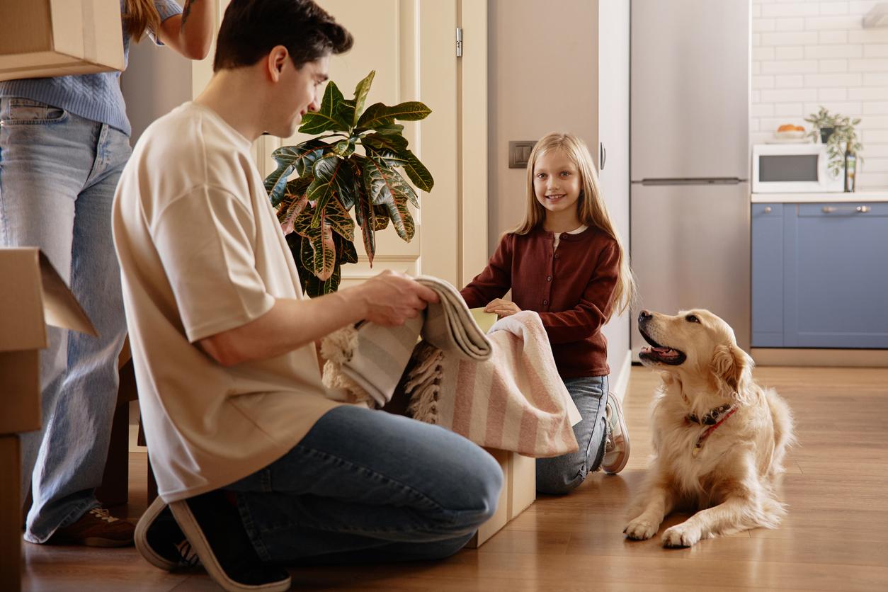 Family with dog packing a box.